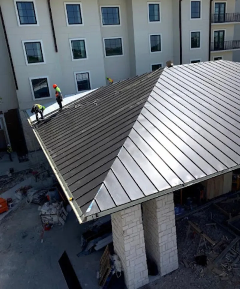 Crew installing standing seam metal roof panels on a commercial project in Camarillo